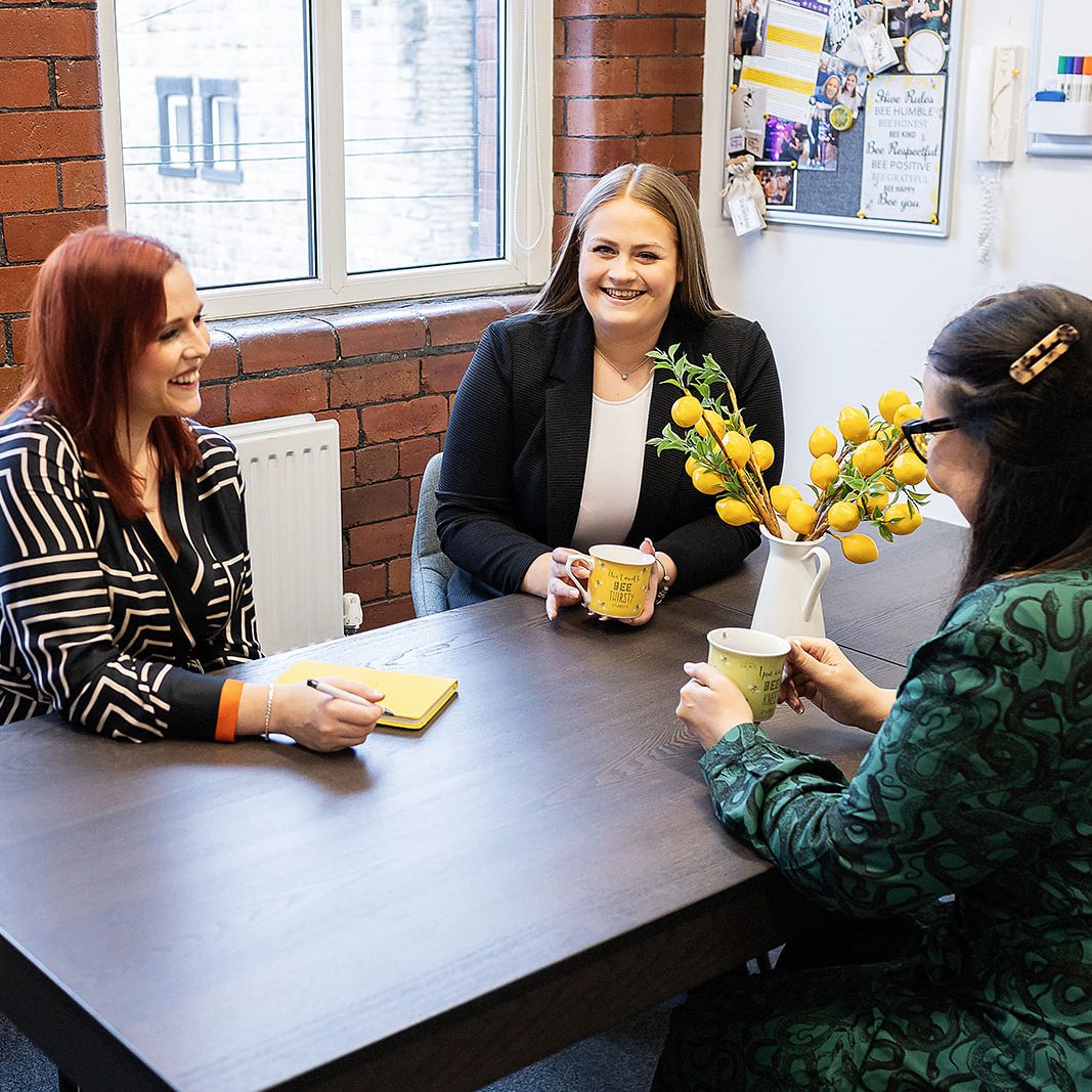 Three girls chatting around a table
